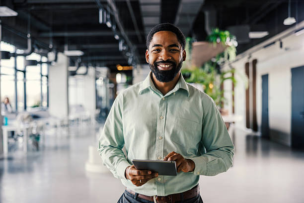 istock Smiling black businessman holding digital tablet in modern office 2254780035