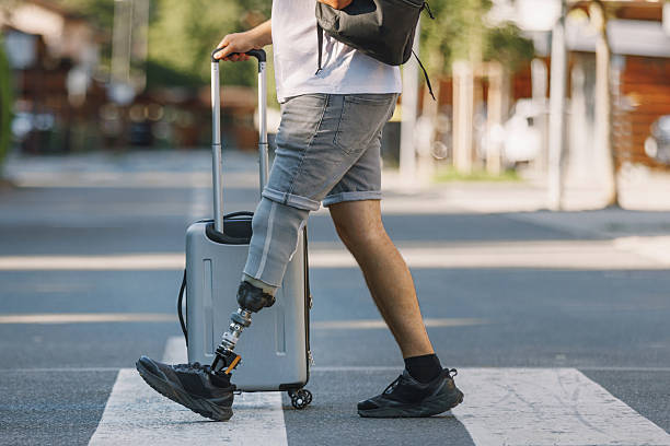 istock Man with disability, with a prosthetic leg, walking across a pedestrian crossing 2254780656