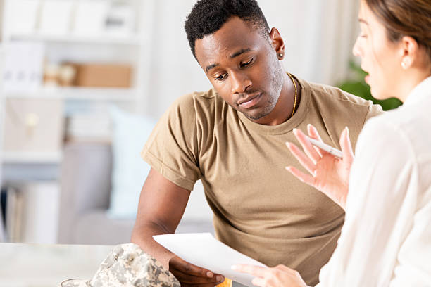 istock Military professional discusses documents with a mental health professional for support. 2254783693