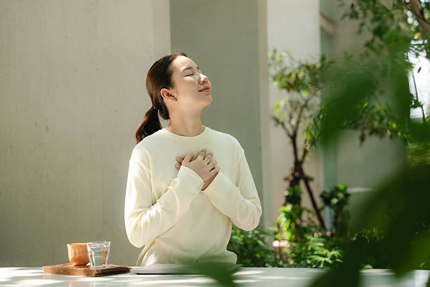 The woman is calming her mind amidst a natural setting.