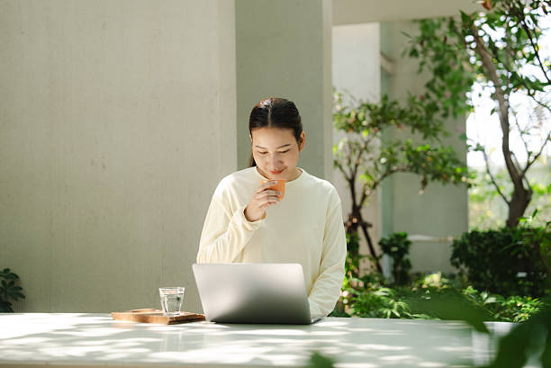 A woman sits working at a nature cafe.