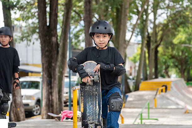 Boy with protections has fun with his bicycle, rest on a bench: