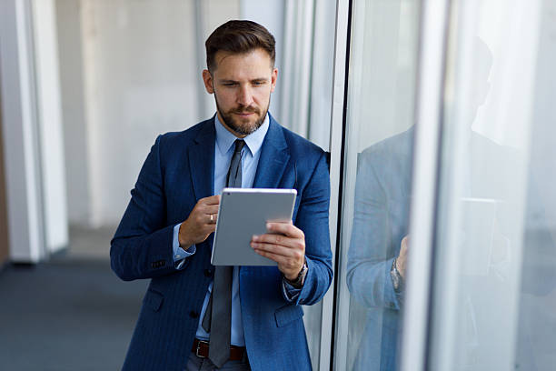 istock Businessman reading on tablet in modern office, managing digital data and remote work technology 2254792376
