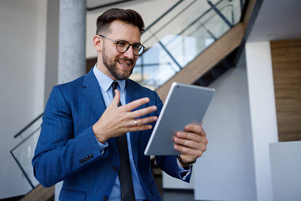 istock Businessman having video call on digital tablet, discussing ideas during virtual meeting from modern office 2254792464