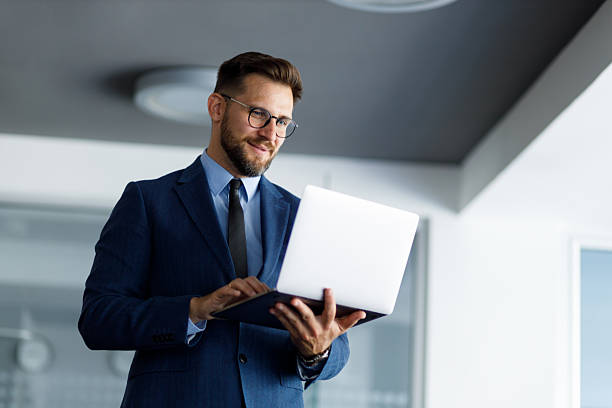 istock Cheerful entrepreneur operating a laptop while in a modern workspace, engaging with digital technology 2254793645