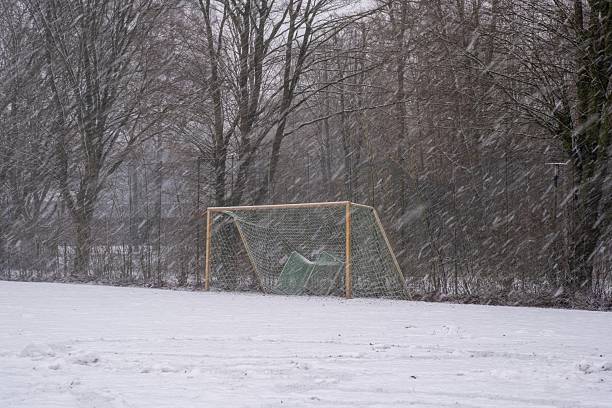 istock Empty soccer field during winter snowfall and cold 2254796041