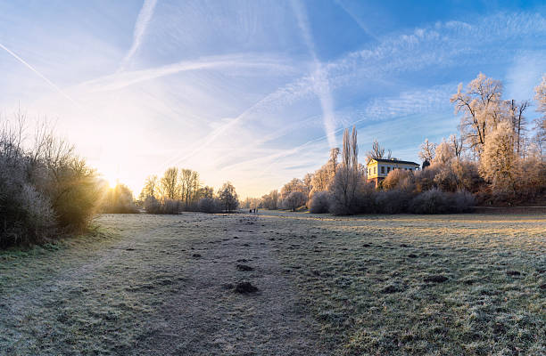 wide panoramic view on frosty meadow in Ilmpark in weimar in the backlit of winter morning sun, stitched image