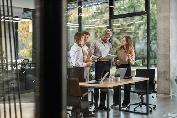 istock A modern office interior, featuring a blurred view of workers at desks, through a glass partition. 2254798266