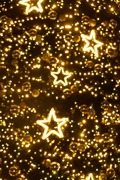 Christmas warm gold garland lights over dark background with glitter overlay