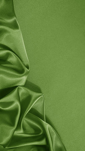 istock Light soft green lime pistachio silk satin. Shiny silky smooth fabric. Wavy folds. Draped. Elegant background. Empty blank space template design ad.Christmas festive birthday.Flat lay, top view table. 2254799840