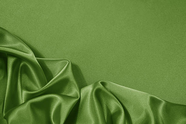 istock Light soft green lime pistachio silk satin. Shiny silky smooth fabric. Wavy folds. Draped. Elegant background. Empty blank space template design ad.Christmas festive birthday.Flat lay, top view table. 2254799855