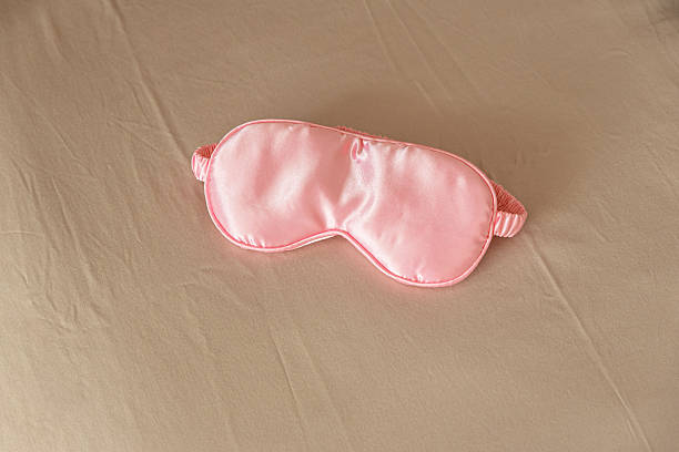 istock Silk sleep mask on a cozy beige bed. 2254802685