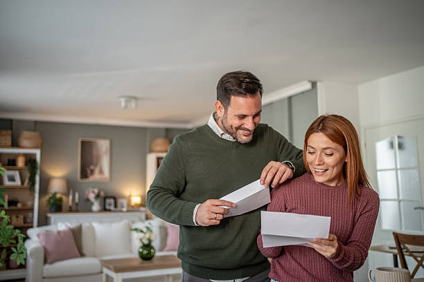 istock Happy couple opening mail at home together 2254803034
