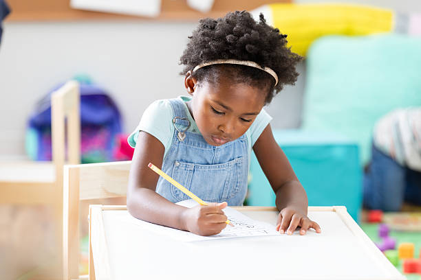 istock Young Black girl focused on writing and learning at a desk 2254803314