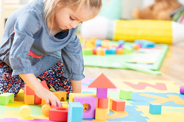 istock Young girl concentrated on building a colorful structure with educational blocks. 2254803358