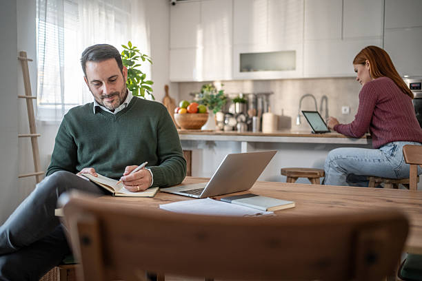 istock Couple working from home together in modern kitchen 2254804347