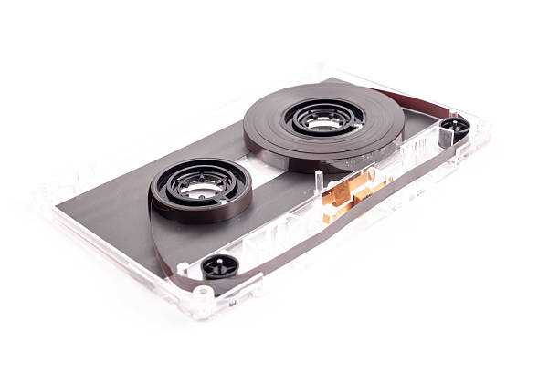 A high-key, clean studio shot of a transparent audio cassette tape laying flat on a pure white surface. The clear plastic casing reveals the intricate internal mechanisms, including the brown magnetic tape, white reels, and copper-colored pressure pad. This isolated object is perfect for graphic designers looking for nostalgic music icons, retro-themed layouts, or concepts related to recording and history.