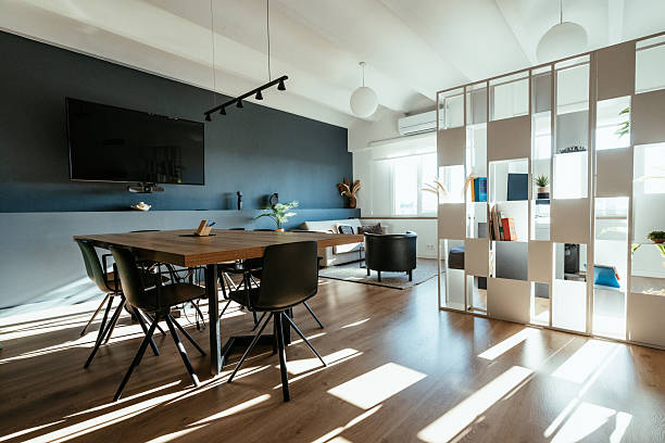 foreground of a living room with leathee sofa, wood floor, overlooking on the kitchen