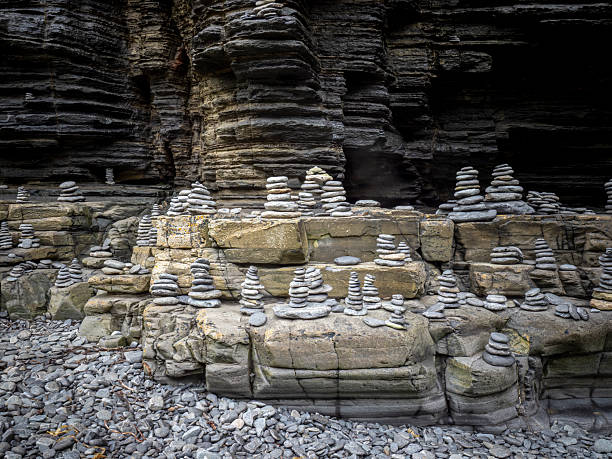 Stacked stones forming rock cairns on a cliff face, symbolizing balance and tranquility