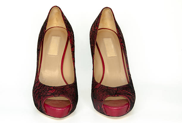 Elegant luxury women’s high heel shoes featuring red and black lace texture with stiletto heel, photographed isolated on a clean white background. Fashion footwear concept suitable for luxury branding, e-commerce, editorial fashion content, and premium style promotions
