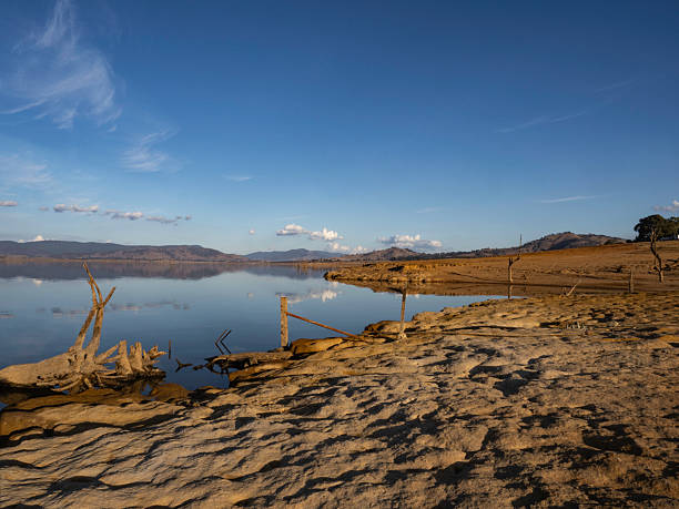 istock Late afternoon sun on reflection lake and red dirt 2254807262