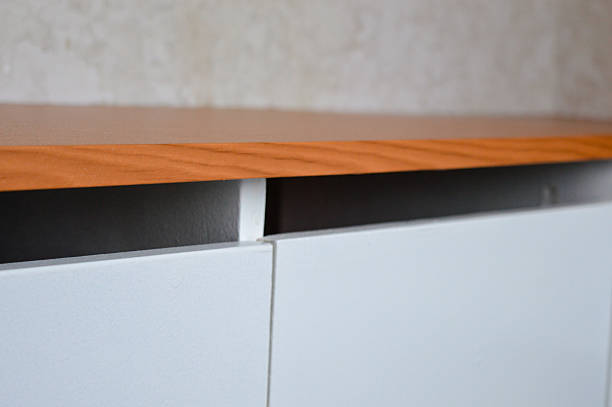 istock Open kitchen cabinet with dishes, utensils, and trays visible under a newly installed wooden countertop. Home organization, kitchen storage, renovation, DIY theme. 2254809277