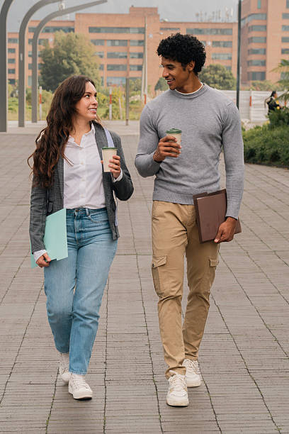 istock Diverse young adult colleagues walking talking holding coffee cups 2254810195