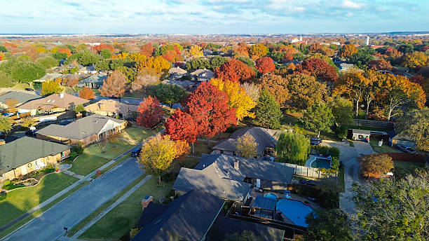 istock Neatly arranged homes in grid-like layout framed by vivid fall foliage in red, orange, yellow. Driveways, rooftops, backyard pools add rhythm to organized suburban tapestry, Coppell, Dallas, TX 2254810702