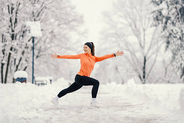 istock Woman exercising outdoors doing stretching in snow 2254812357