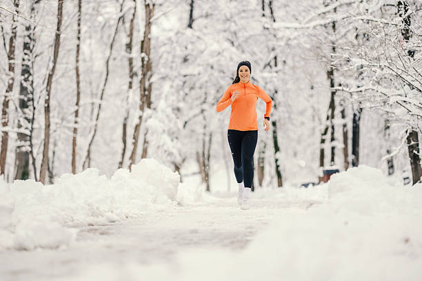 istock Woman running on snow covered path in winter park 2254812379