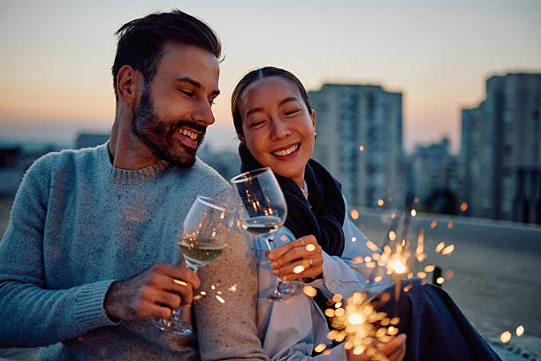 istock Happy couple toasting wine celebrating with sparklers 2254816125