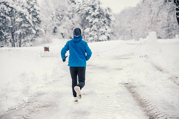 istock Man running on snowy road in winter park 2254817213