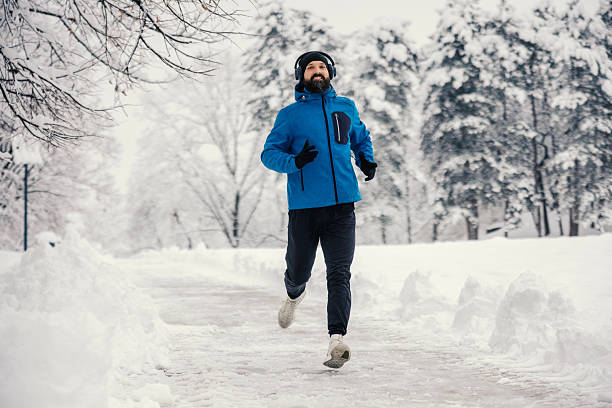 istock Man running in winter park, enjoying snow jog 2254817239