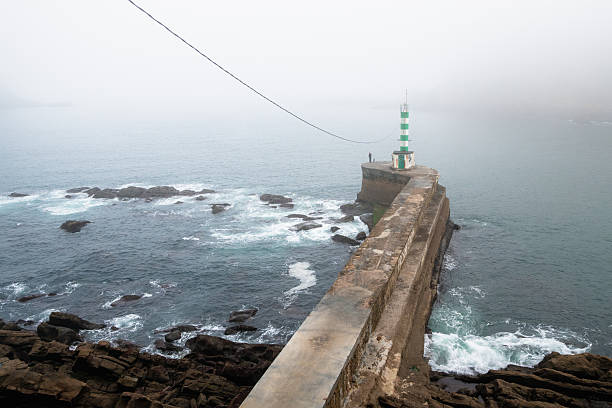 Foggy morning at sea side with fisherman