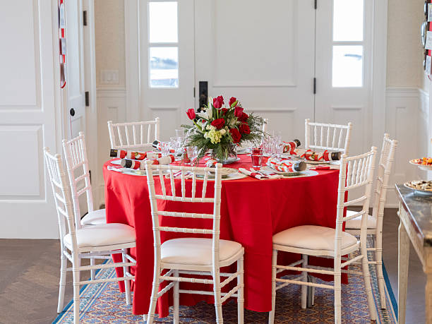 istock Table with a red tablecloth and white chairs is set for a Christmas holiday dinner party 2254819015
