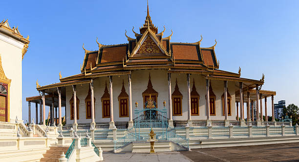 Phmon Penh, Cambodia - December 11, 2015: Monks, tourists and local people walk along the street near the walls of the royal palace in the capital of Cambodia, Phnom Penh.