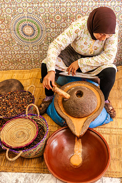Moroccan woman producing argan oil by traditional methods. Argan oil is a plant oil produced from the argan tree that is endemic to Morocco. The argan oil is used for cosmetic purposes
