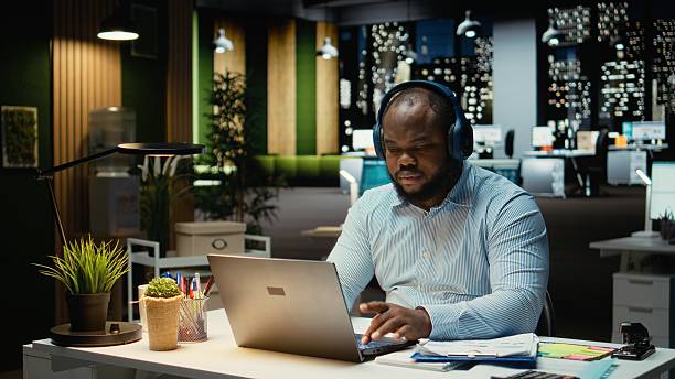 istock Black person managing daily tasks after hours with focus music on headset 2254824861