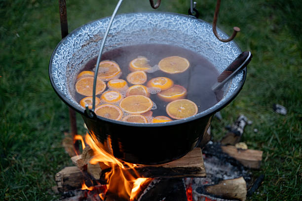 istock Hot mulled drink with orange slices cooking over fire 2254827685