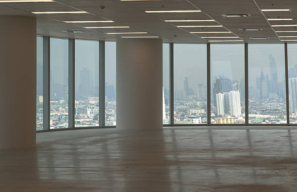 Professionals engaging in a dynamic modern office setting, with individuals interacting and working efficiently. Natural light streams through large windows, enhancing the open and collaborative atmosphere. A sense of focus and productivity pervades the workspace, fostering a vibrant and energetic environment.