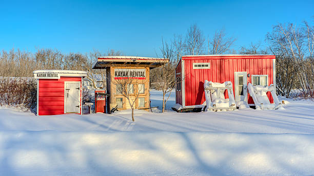 A construction trailer with multiple windows parked on a snow-covered construction site, illustrating the concept of shift housing for workers in industrial settings during cold, wintry conditions.