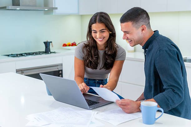 istock Happy Young couple working on paperwork or home finances in the kitchen. 2254828619