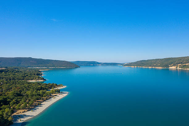 istock Wide tranquil lake bordered by forested hills 2254832883
