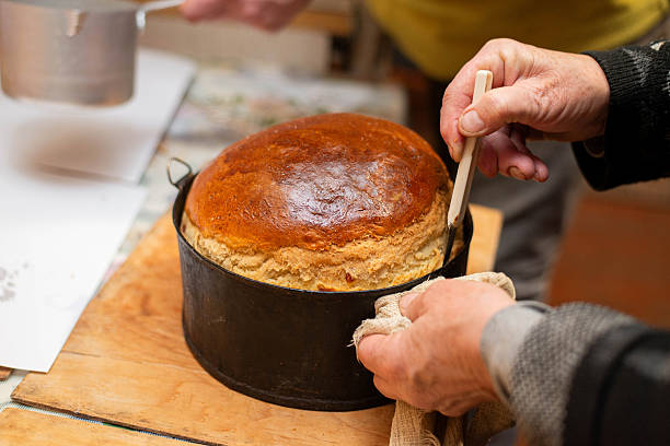 Homemade bread in metal baking mold being removed after baking