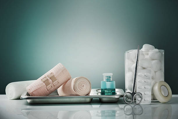 erste-hilfe-kit und notfallmaterial auf einer weißen oberfläche mit grünem studio-hintergrund. konzept von gesundheitsversorgung, sicherheit und notfallvorsorge für kliniken, krankenhäuser und häusliche pflege. - medizinisches material stock-fotos und bilder