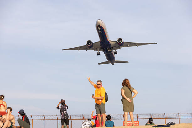 30 December 2025, Mai Khao Beach - Phuket Island.Tourists taking picture with commercial airplane on Mai Khao Beach in Phuket. The area is less crowded than many other beaches in Phuket.