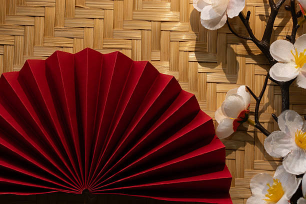 Minimalist and elegant flat lay of Asian New Year symbols. Woven bamboo texture provides a perfect natural background for festive content.