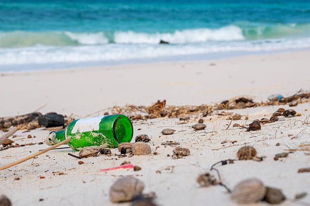 Beach litter and glass bottle highlight coastal pollution, climate crisis, and urgent call for eco-action—perfect for sustainability ads and cleanup awareness campaigns.