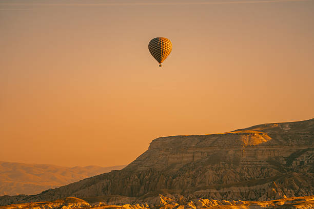 Cappadocia hot air balloons drifting above soft rock formations, featuring warm tones, calm skies, and iconic valley scenery.