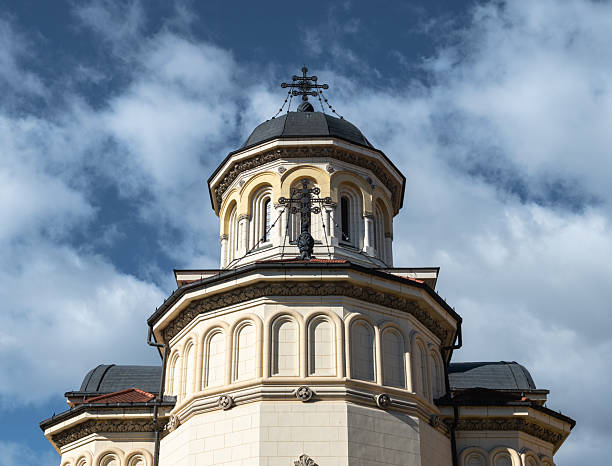 Alba Iulia, Romania - october 19.2025. The historic Orthodox Coronation Cathedral features ornate white stone architecture and dark domes under a bright blue sky